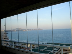 Paneles deslizantes de cristal transparente para el cerramiento exterior de una terraza junto al mar.